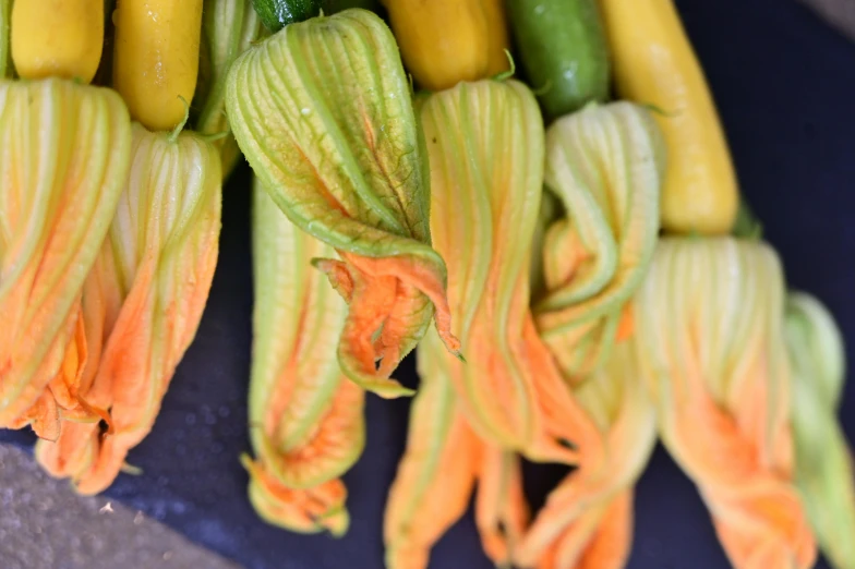 a bunch of zucchini flowers sitting on top of a cutting board, by Carey Morris, unsplash, renaissance, square, bells, made of glazed, swirling