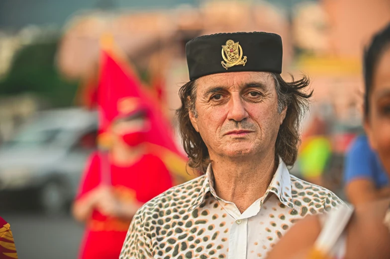 a close up of a person wearing a hat, an album cover, by Giuseppe Avanzi, dressed as emperor, traditional corsican, mullet, street photo