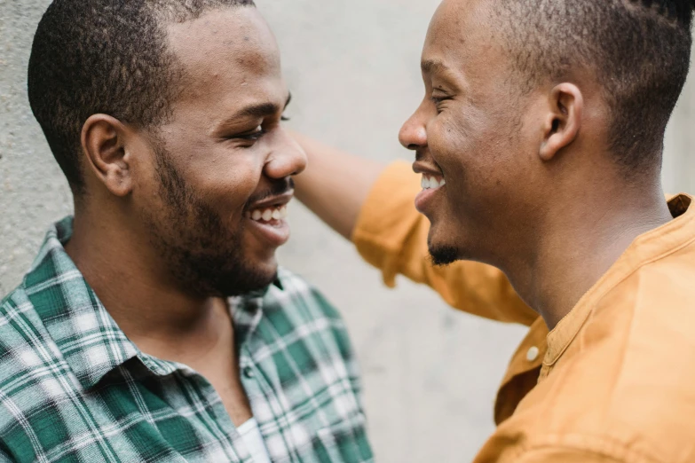 a couple of men standing next to each other, trending on unsplash, happening, brown skin man with a giant grin, kissing each other, coloured, multiple stories