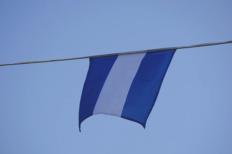 a blue and white flag hanging on a clothes line, square, ((blue)), finnstark, medium - shot