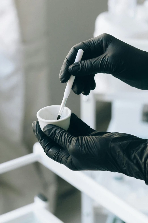 a person in black gloves holding a white cup, process art, medical lab, coating a stubborn core.', black, surgical supplies