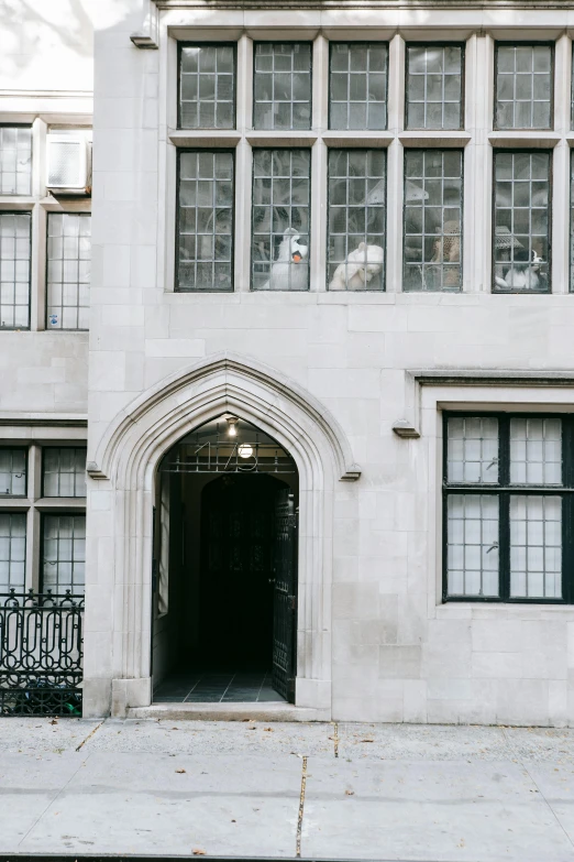 a white building with a red fire hydrant in front of it, by Nina Hamnett, trending on unsplash, arts and crafts movement, tall arched stone doorways, 1920's london street, silver，ivory, doves