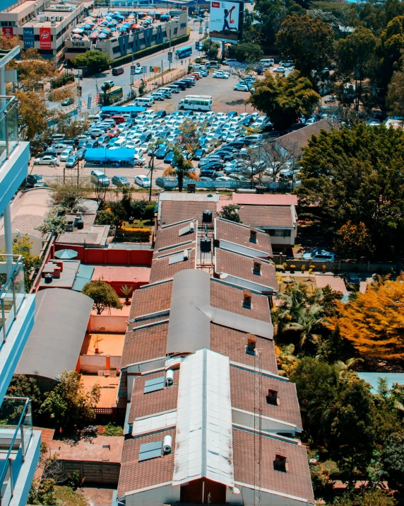 a view of a city from the top of a building, parked cars, manly, colorful caparisons, low quality photograph