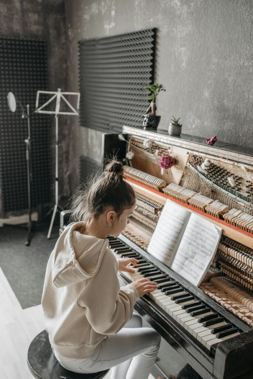 a girl sitting on a stool playing a piano, pexels contest winner, in a studio hollow, school class, ouchh and and innate studio, instagram post