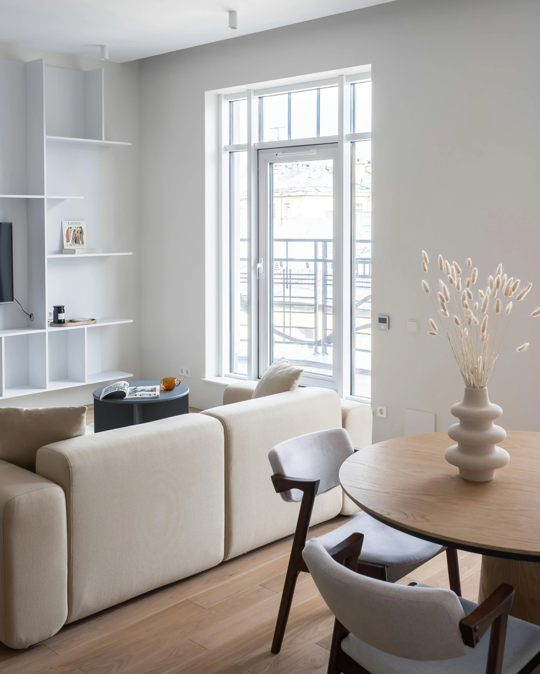 a living room filled with furniture and a wooden table, inspired by Constantin Hansen, unsplash contest winner, light and space, cream and white color scheme, inside the building, modern minimalist f 2 0 clean, muted palette mostly white