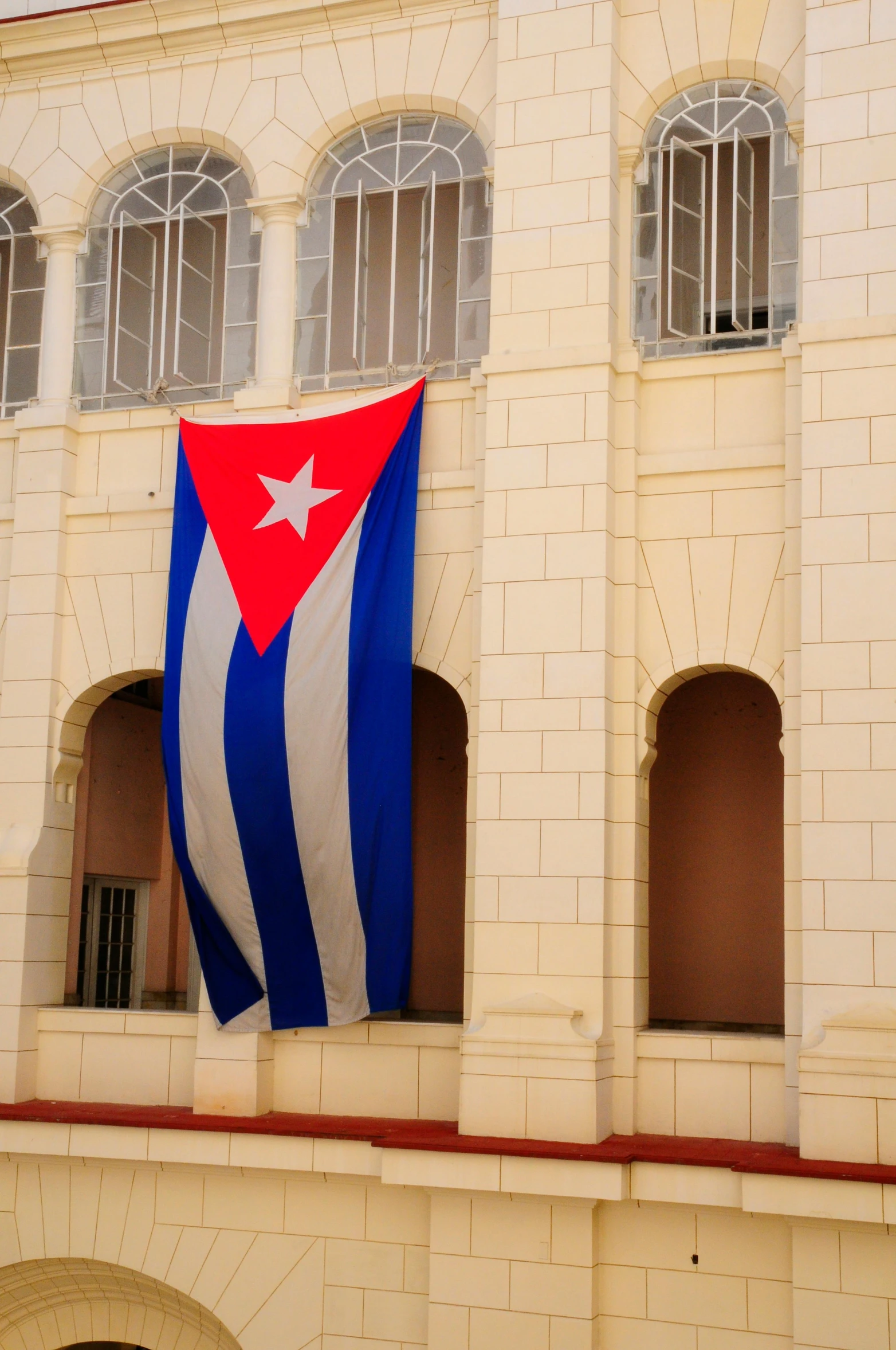 a large flag hanging from the side of a building, inspired by Raúl Martínez, cuba, square, historical