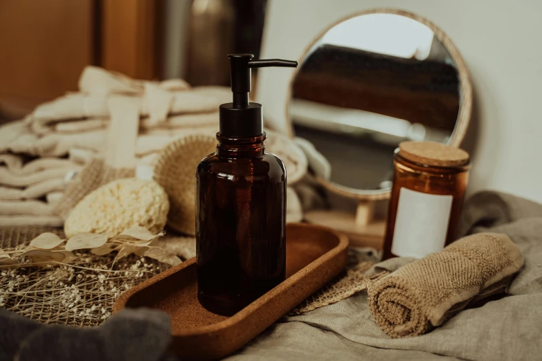 a bottle of liquid sitting on top of a wooden tray, by Julia Pishtar, trending on pexels, soap, various posed, brown, sustainable