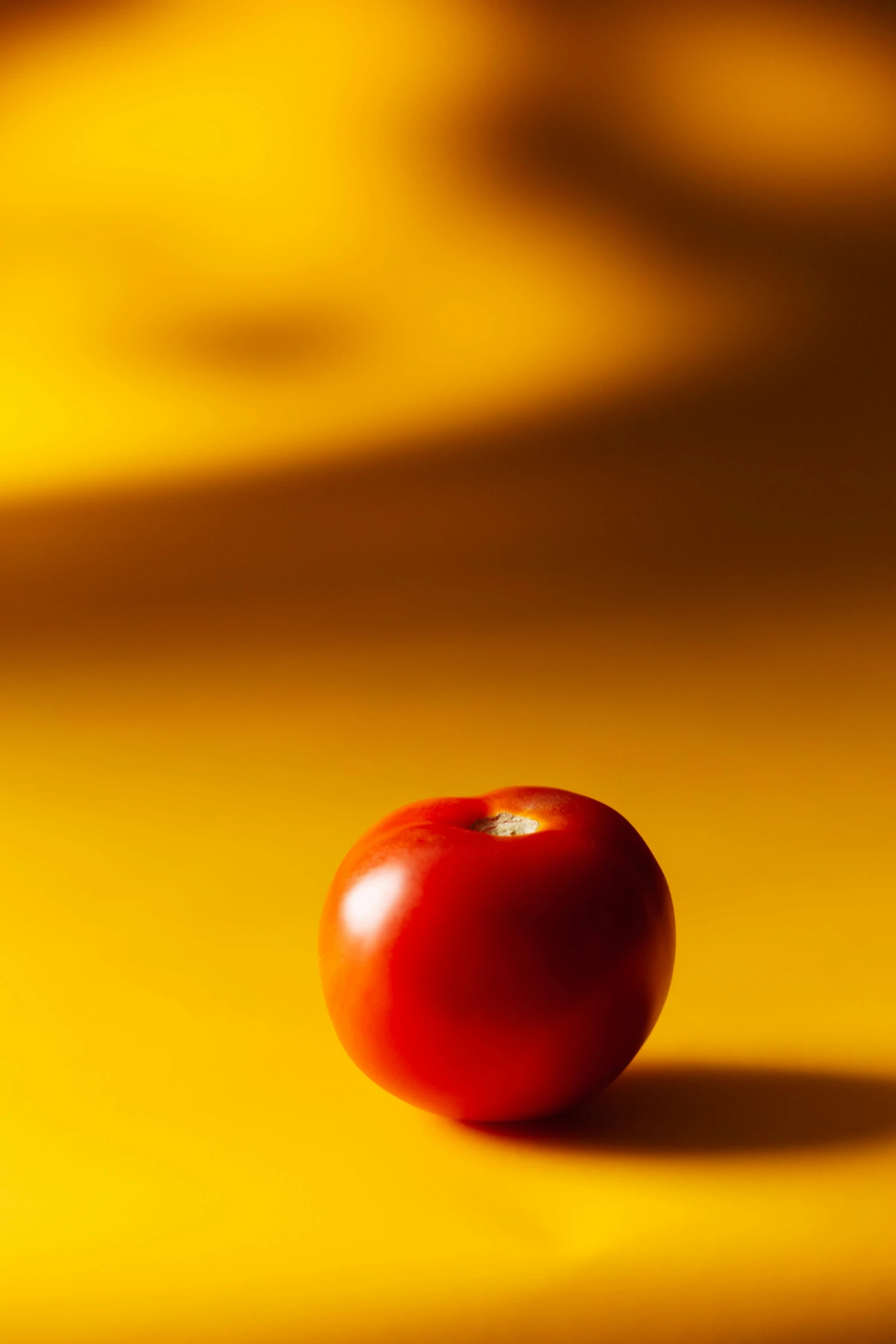 a red apple sitting on top of a yellow surface, ap news photo, tomato, tiltshift, still life photo of a backdrop