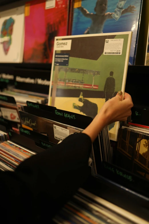 a person holding a record in a record store, an album cover, by Ottó Baditz, happening, aphex twin, thumbnail, shelf, during the night