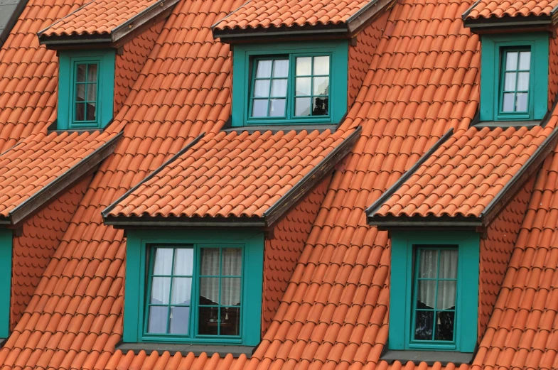 a group of windows that are on the side of a building, by Adam Marczyński, pixabay, orange roof, square, shot from roofline, green and orange theme