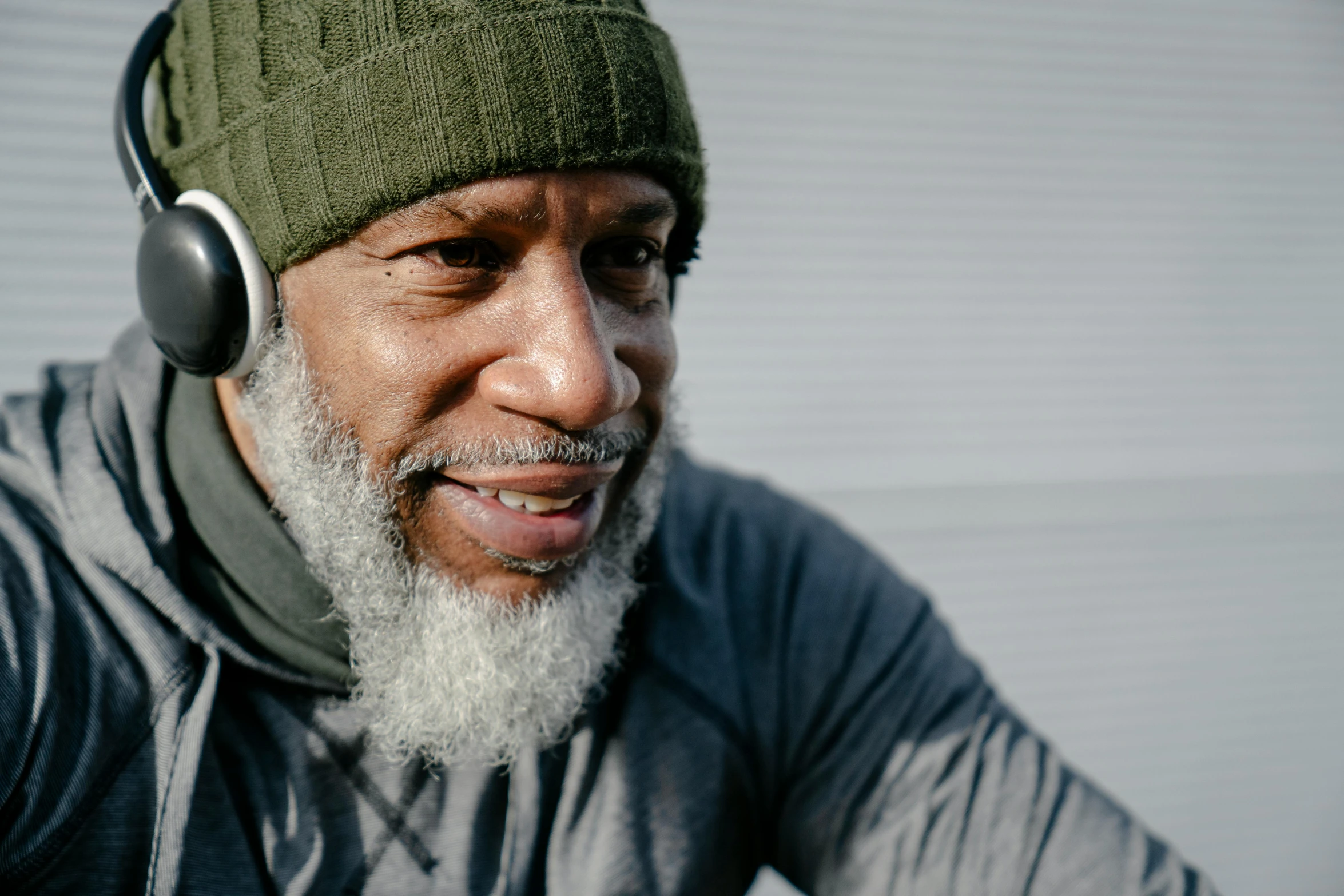 a close up of a person wearing headphones, inspired by Fred Mitchell, trending on pexels, renaissance, grey beard, wearing fitness gear, thumbnail, man is with black skin