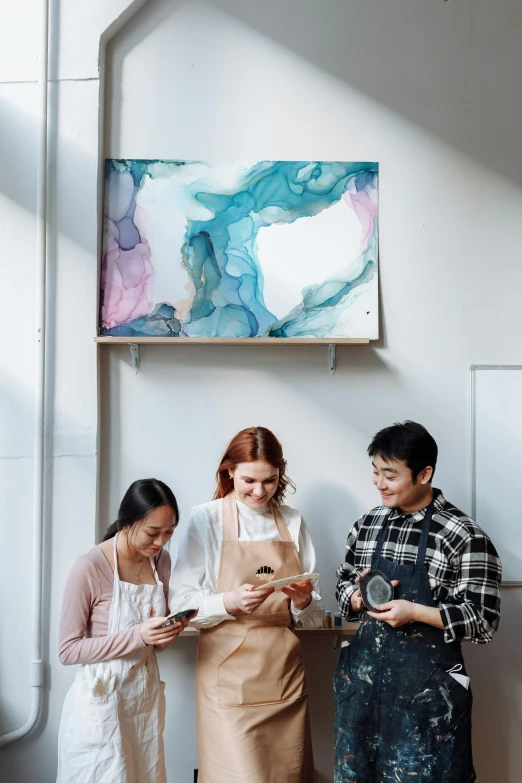 a group of people standing next to each other in a room, a painting, trending on pexels, interactive art, aussie baristas, integrating with technology, asian descend, pastel artwork