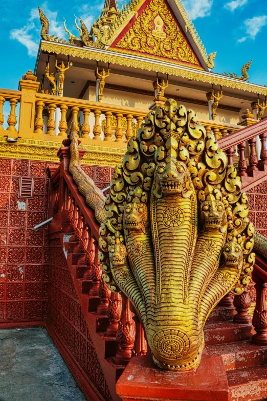 a statue of an elephant in front of a building, red and golden color details, sitting on temple stairs, futuristic phnom-penh cambodia, ornate spikes