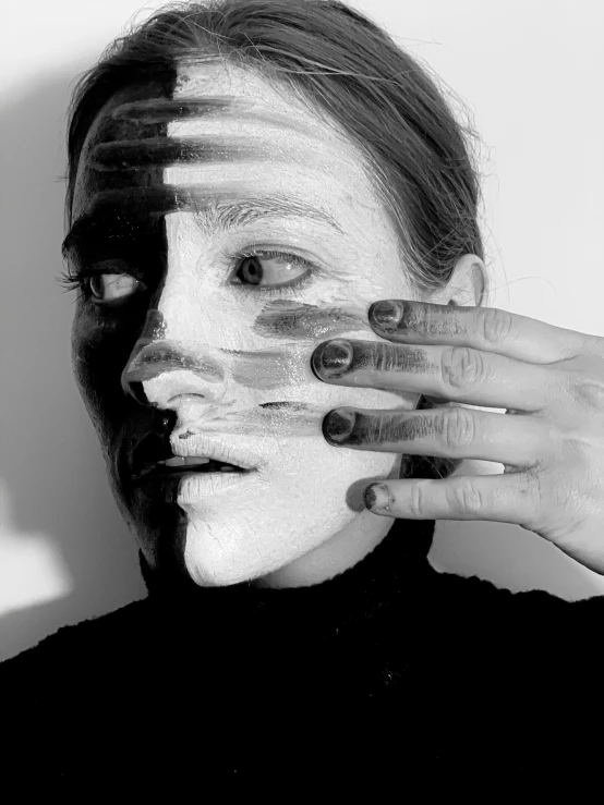a black and white photo of a woman with white paint on her face, a black and white photo, inspired by Dora Maar, hands shielding face, face mask, mandy jurgens golden ratio, half and half