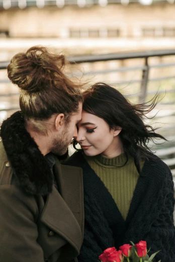 a man and woman sitting next to each other on a bench, a photo, trending on pexels, renaissance, messy manbun, wearing a turtleneck and jacket, her hair blowing in the wind, embracing