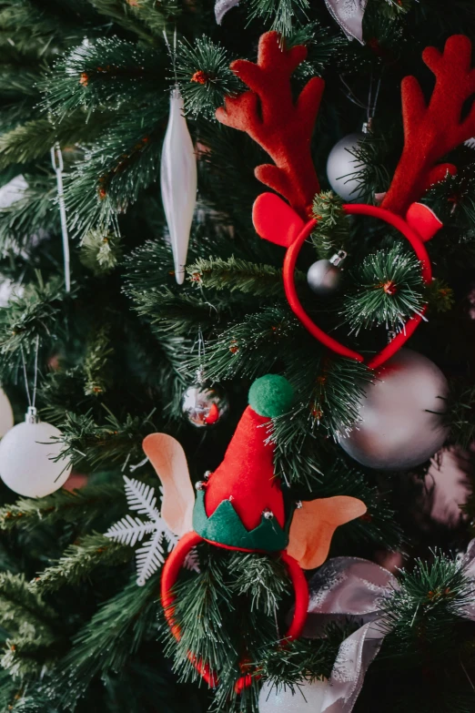 a close up of a christmas tree with ornaments, elf ears, crown made of fabric, zoomed out shot, product shot