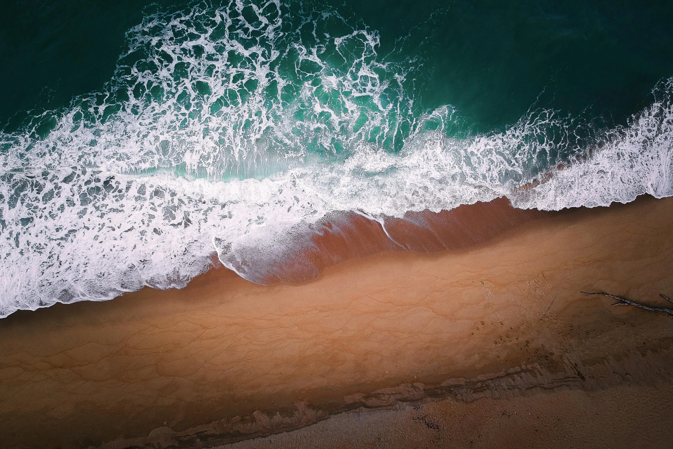 a large body of water next to a sandy beach, by Robbie Trevino, pexels contest winner, close-up from above, ocean spray, unsplash photo contest winner, multiple stories