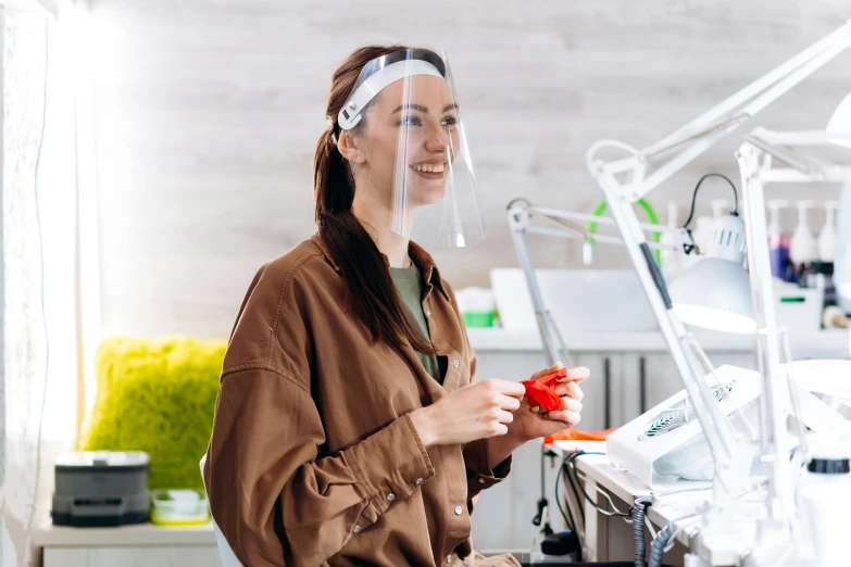 a woman standing in a dentist's chair holding a pair of scissors, by Adam Marczyński, pexels contest winner, smooth transparent visor, smiling mask, sitting on a lab table, glowforge template