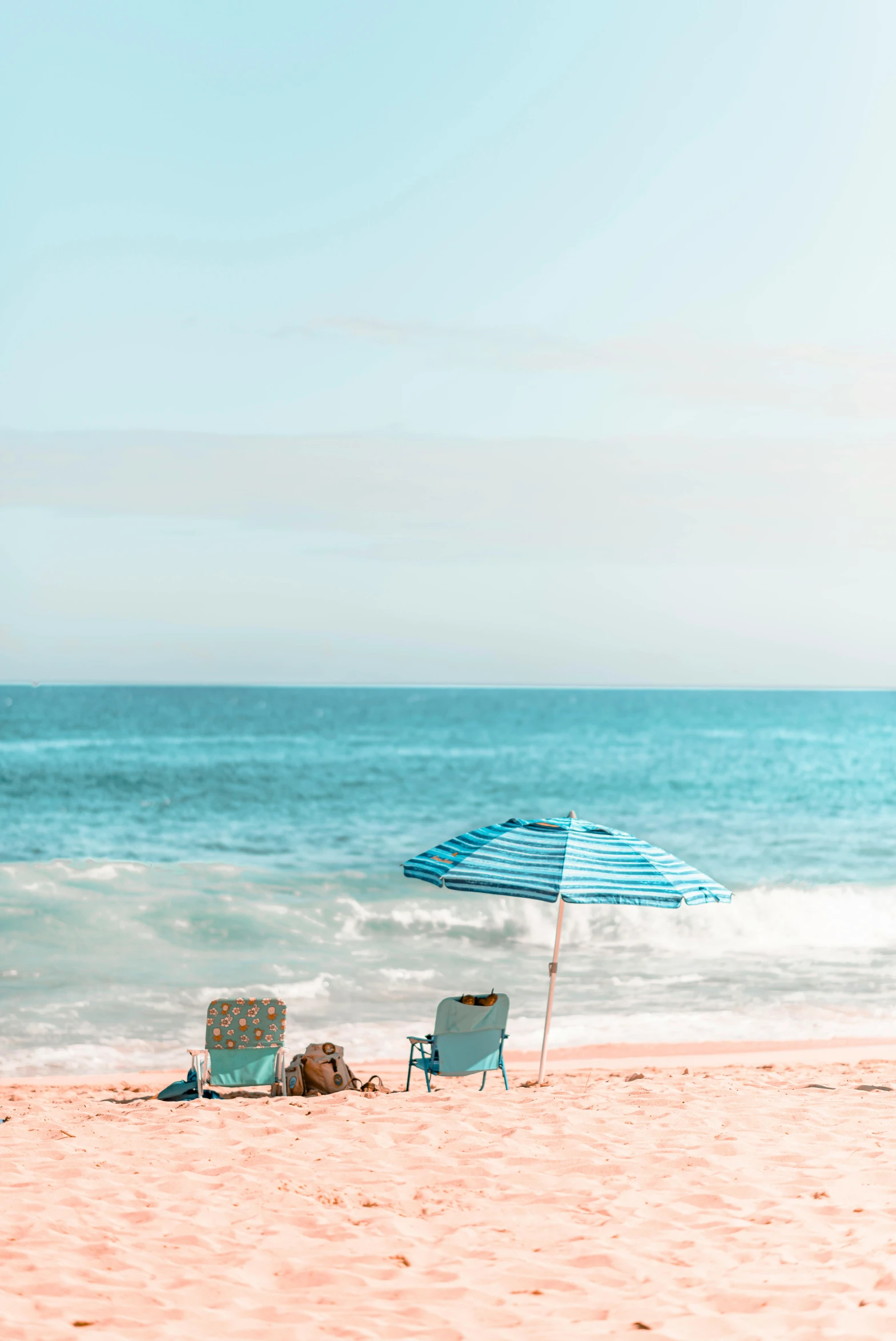 a couple of lawn chairs sitting on top of a sandy beach, by Kristin Nelson, trending on unsplash, umbrellas, pastel blue, kauai, profile image