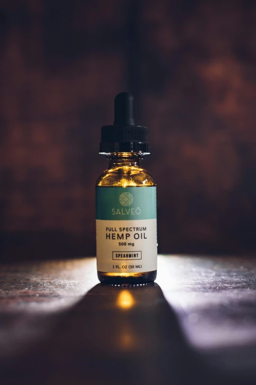 a bottle of hemp oil sitting on a table, a picture, by Jason Benjamin, unsplash, on textured base; store website, sundown, detailed product image, suave