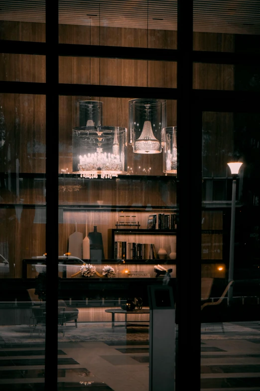 a view of a living room through a window, inspired by Elsa Bleda, pexels contest winner, scene from a dinner party, chandeliers, cafe lighting, nesting glass doors