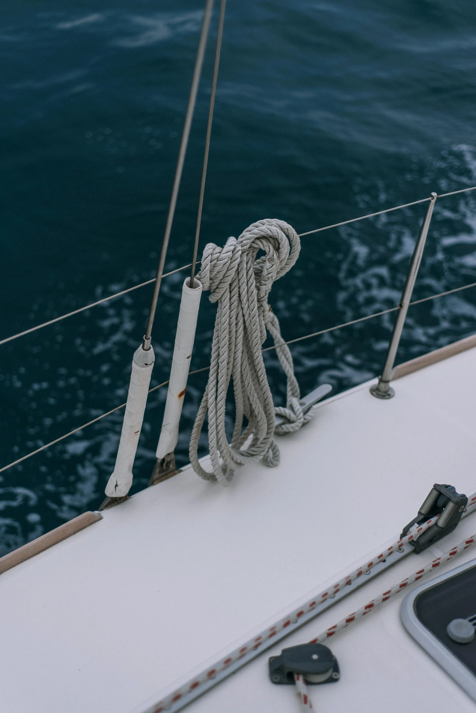 a close up of a boat on a body of water, rope, a high angle shot, zoomed in, looking off to the side