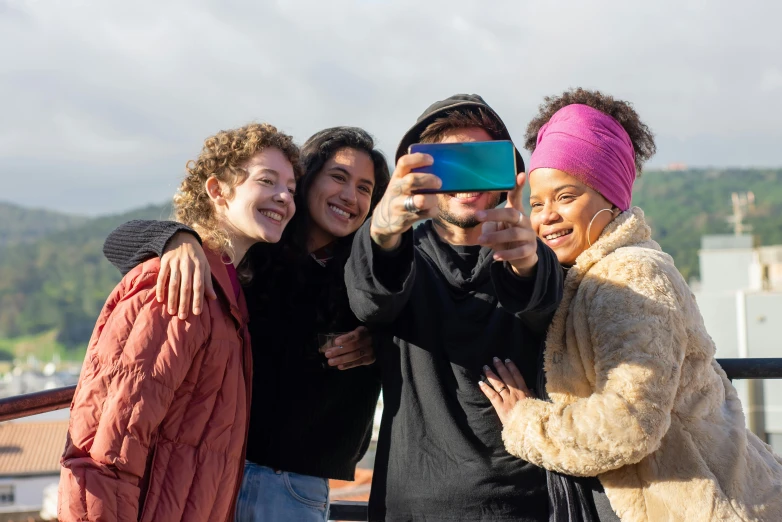 a group of people taking a picture with a cell phone, nathalie emmanuel, with black beanie on head, bay area, embracing