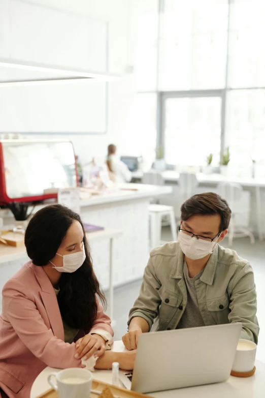 a couple of people sitting at a table with a laptop, by Jang Seung-eop, trending on pexels, renaissance, medical mask, in office, very hazy, center of image