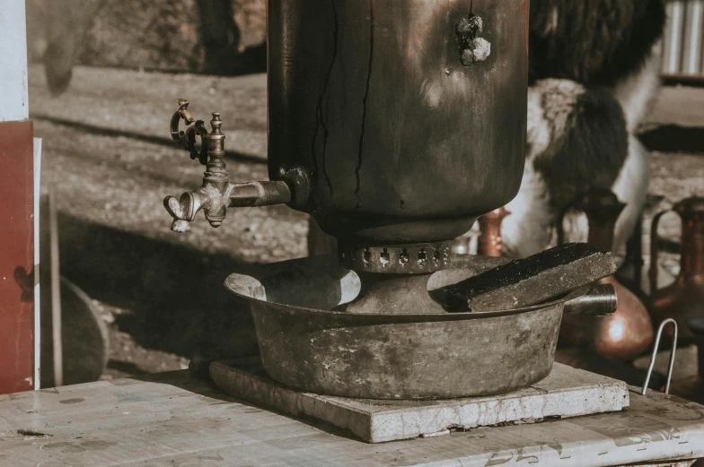 a large metal pot sitting on top of a wooden table, trending on unsplash, process art, water fountain, rusty meat machine, historical image, thumbnail