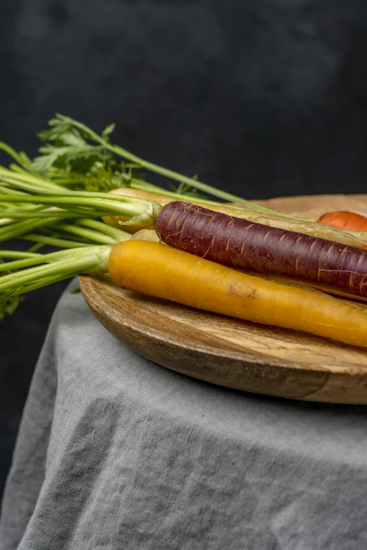 a bunch of carrots sitting on top of a wooden plate, a still life, by Jan Tengnagel, unsplash, portrait n - 9, multi colored, side light, detailed product image