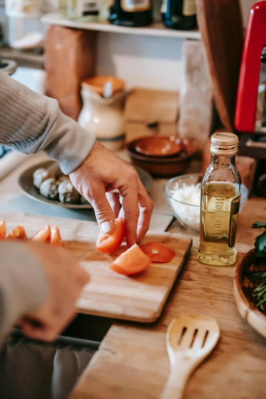 a person chopping tomatoes on a cutting board, a picture, pexels contest winner, renaissance, cooking oil, at a dinner table, full-body, hygge