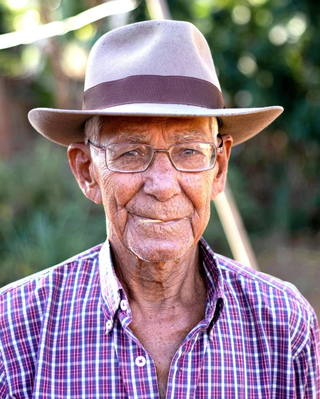 an older man wearing a hat and glasses, by Peter Churcher, indigenous man, wearing farm clothes, lgbtq, portrait image