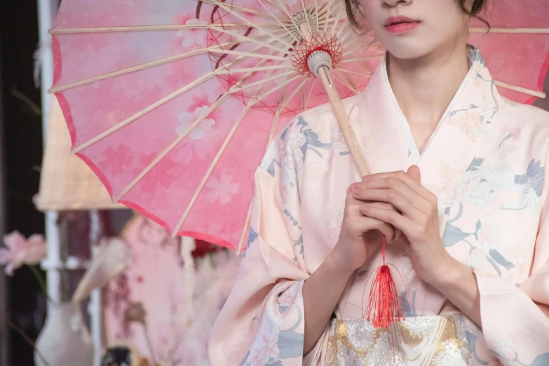 a woman in a kimono is holding an umbrella, inspired by Uemura Shōen, trending on unsplash, pink pastel, cosplay photo