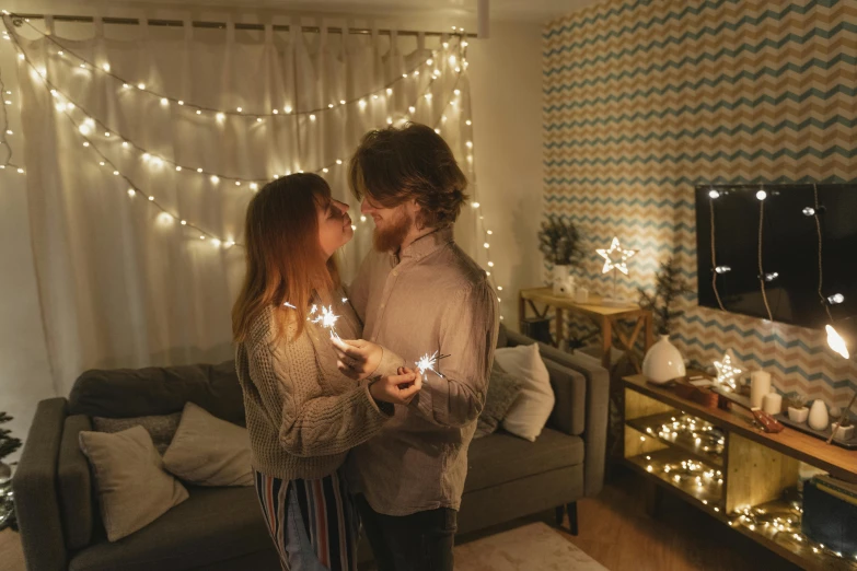 a man and a woman holding sparklers in their hands, pexels contest winner, romanticism, inside a cozy apartment, led light strips, in a living room, making out