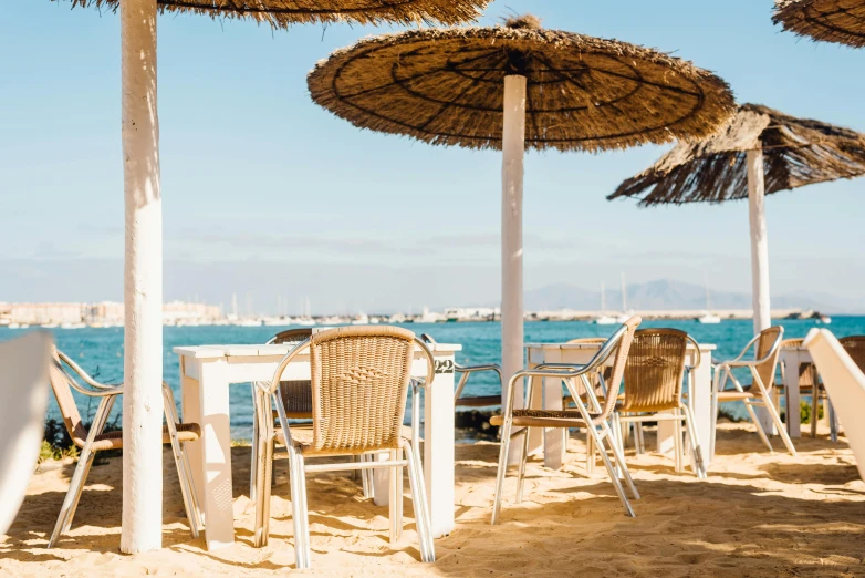 a number of chairs and umbrellas on a beach, pexels contest winner, un restaurant avec une terrasse, avatar image, costa blanca, julia sarda