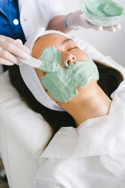 a woman getting a facial mask at a beauty salon, by Julian Allen, seafoam green, gooey skin, eucalyptus, skin texture