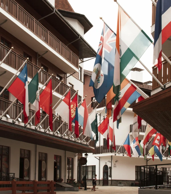 a group of flags hanging from the side of a building, hotel, at the terrace, courtyard walkway, tudor