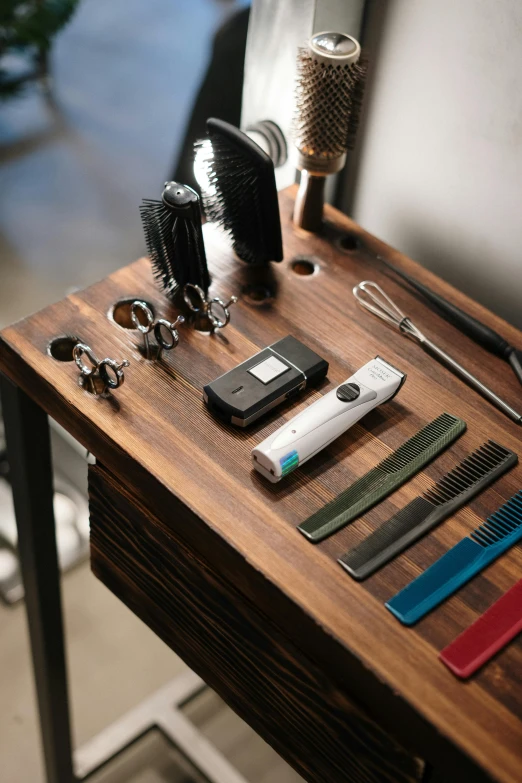 a table topped with tools on top of a wooden table, groomed facial hair, product display, multiple stories, styling