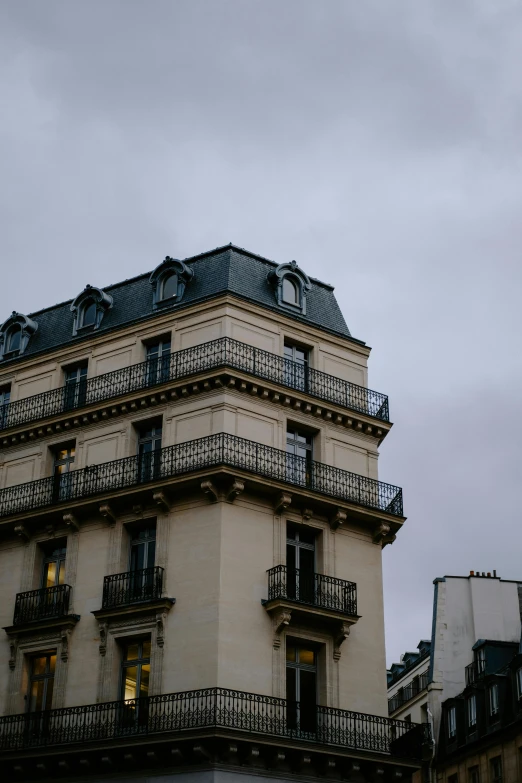 a tall building with a clock on top of it, unsplash, paris school, overcast dusk, high quality photo, old apartment, rounded roof