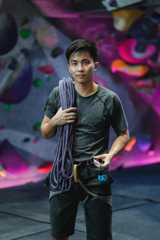 a man standing in front of a climbing wall, by Reuben Tam, profile picture, mei-ling zhou, on a dark background, maintenance