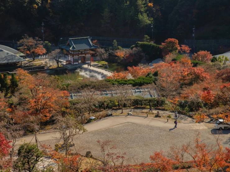 a group of people standing on top of a lush green field, inspired by Baiōken Eishun, pexels contest winner, sōsaku hanga, red leaves on the ground, himeji rivendell garden of eden, wide high angle view, autumn leaves on the ground