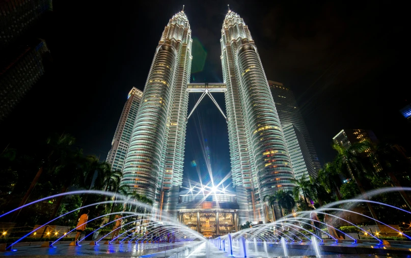 the petrona towers are lit up at night, pexels contest winner, hurufiyya, thumbnail, ground level view, pov, 8k resolution”