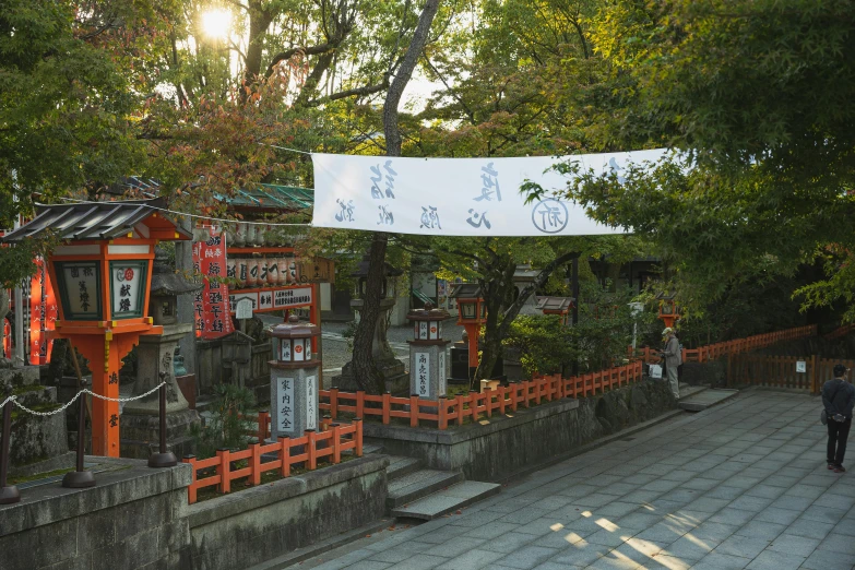 a sign hanging from the side of a building, inspired by Sesshū Tōyō, unsplash, sōsaku hanga, orange and white color scheme, an altar of a temple, early morning light, giant cherry trees