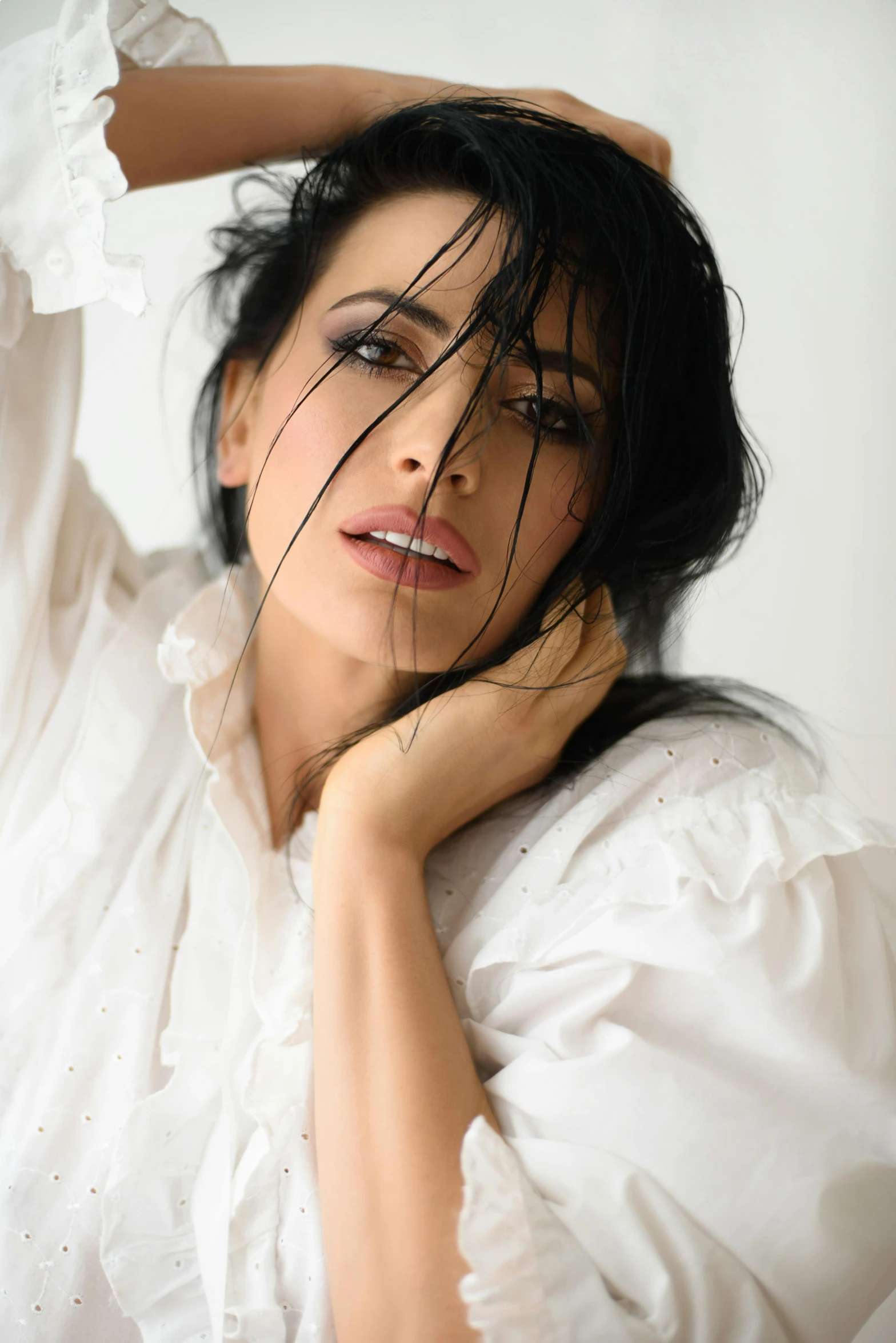 a woman in a white shirt posing for a picture, inspired by Rudolf von Alt, trending on pexels, art nouveau, messy black hair, meni chatzipanagiotou, actress, high key lighting