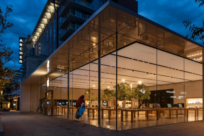 an apple store is lit up at night, a digital rendering, unsplash, paler. millions of glass-walled, utah, square, uk