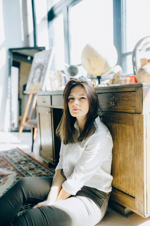 a woman sitting on the floor next to a dresser, a portrait, by Julia Pishtar, pexels contest winner, arbeitsrat für kunst, sitting on a desk, summer glau, headshot profile picture, james jean andrei riabovitchev