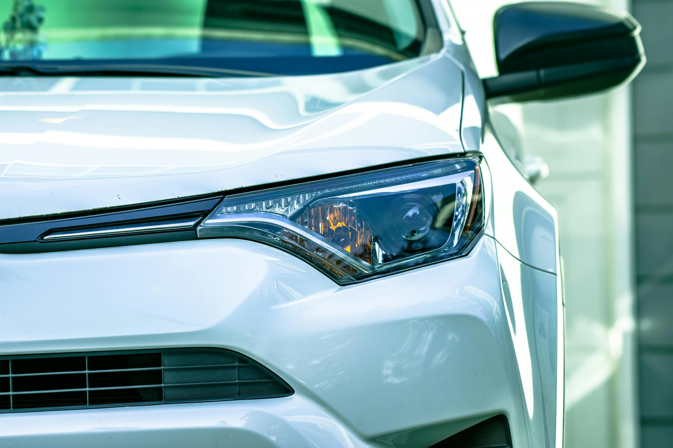 a close up of the front of a white car, by Carey Morris, pexels contest winner, cyan headlights, accompanying hybrid, perfect crisp sunlight, shot on canon eos r5