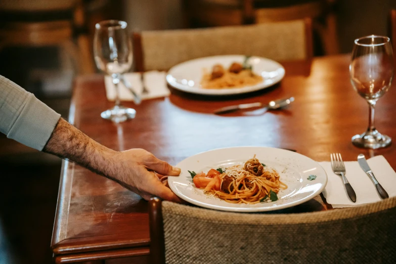 a close up of a plate of food on a table, by Arabella Rankin, pexels contest winner, renaissance, throwing spaghetti and meatballs, standing in a restaurant, lachlan bailey, a single