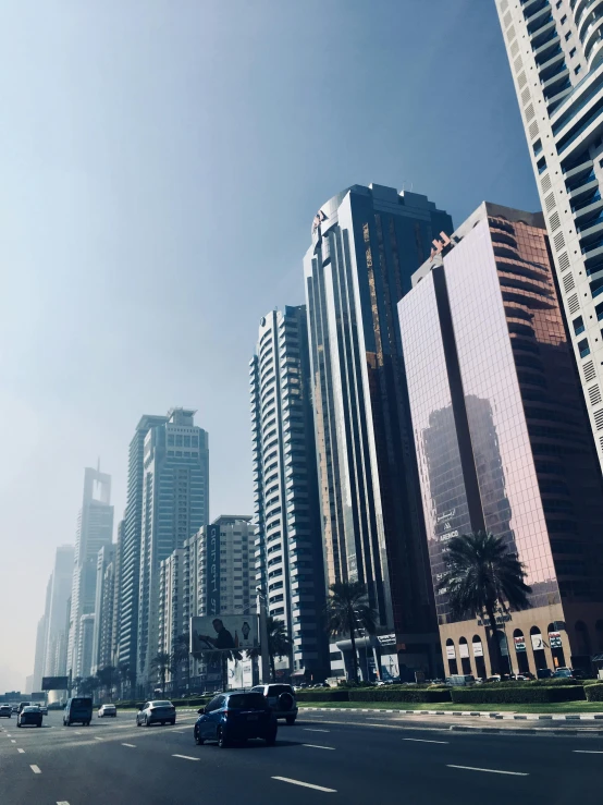 a city street filled with lots of tall buildings, pexels contest winner, ameera al taweel, smoke in front, slightly sunny, tropical coastal city