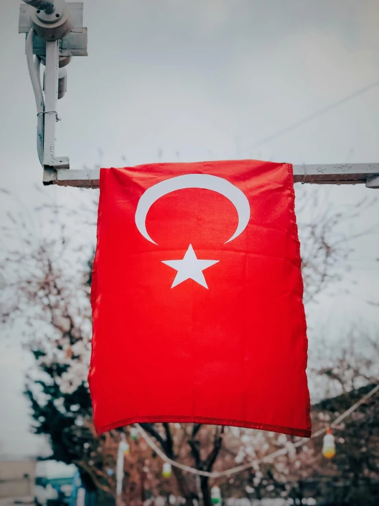 a turkish flag hanging from a street light, pexels contest winner, hurufiyya, instagram story, profile image, carson ellis, high quality product image”